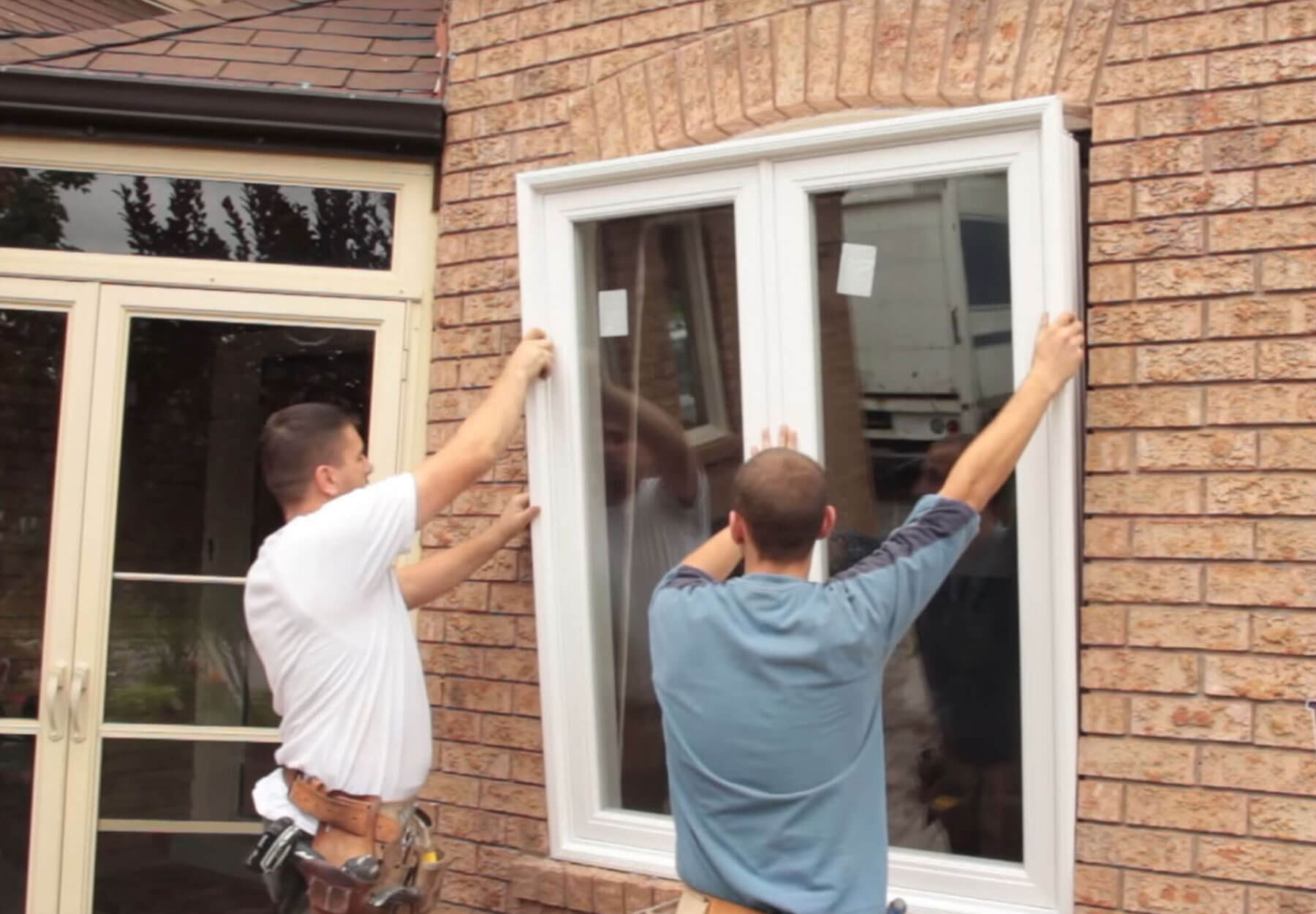 Two men installing a window