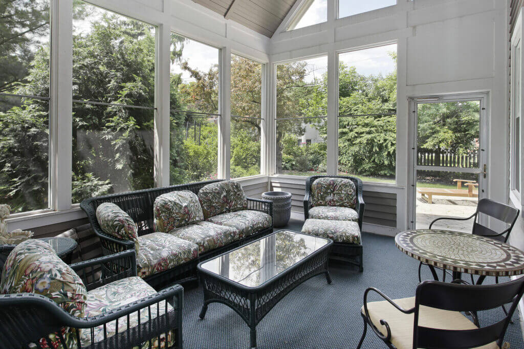 A view from inside a furnished sunroom